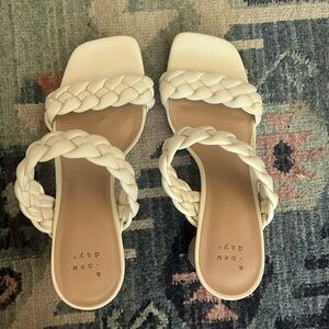 White sandals. Braided design with a small heel.